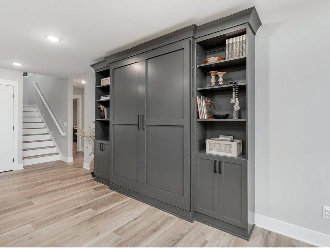 Finished charcoal built-in cabinetry with open shelves and closed storage in a living room